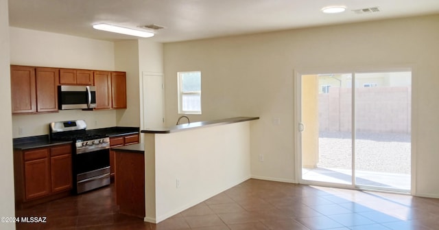 kitchen featuring kitchen peninsula, stainless steel appliances, and tile patterned floors