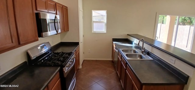 kitchen with sink, black gas stove, and dark tile patterned flooring