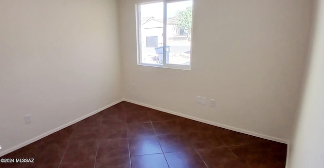 unfurnished room with dark tile patterned flooring