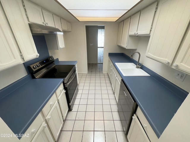 kitchen with electric range oven, sink, light tile patterned floors, stainless steel dishwasher, and white cabinetry