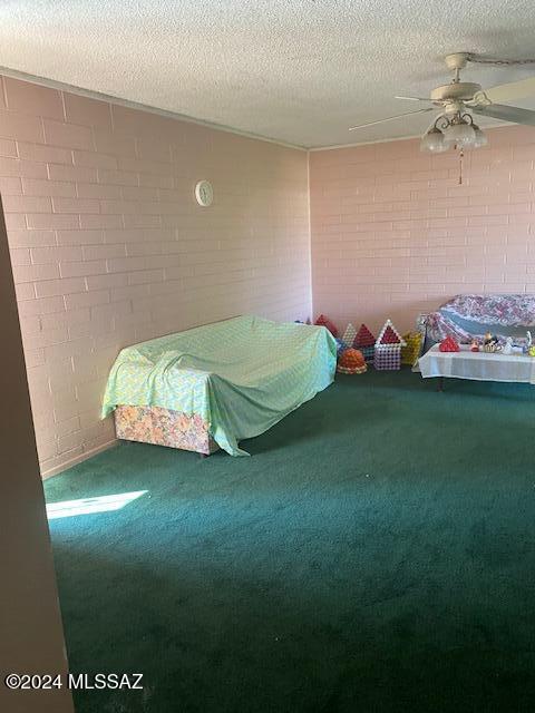 unfurnished bedroom featuring a textured ceiling, carpet, and ceiling fan