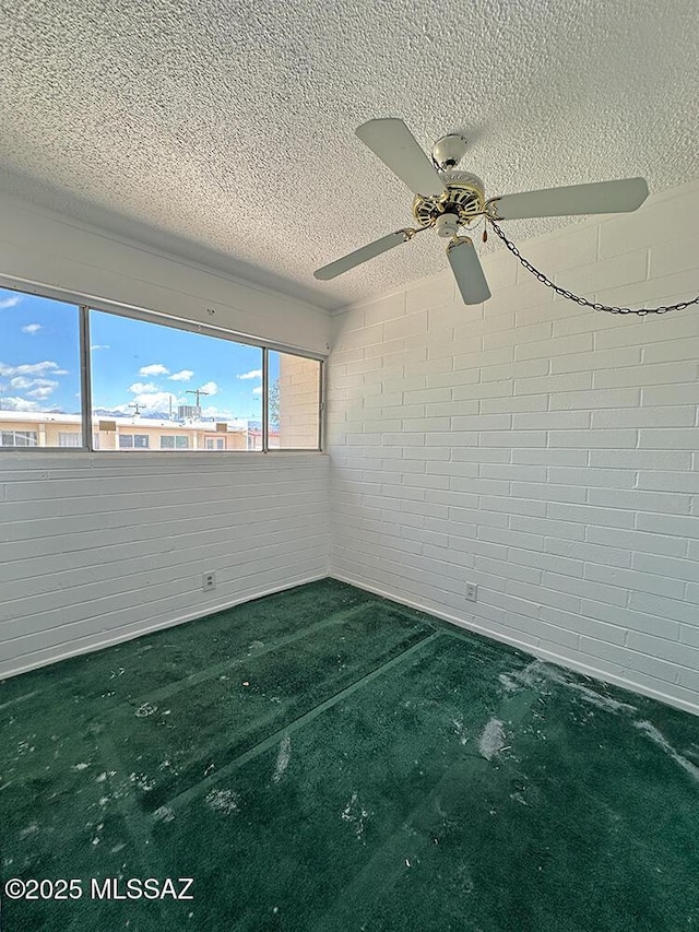 empty room with carpet flooring, a textured ceiling, and ceiling fan
