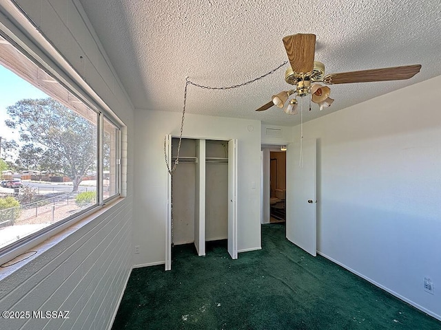 unfurnished bedroom featuring a textured ceiling, a closet, ceiling fan, baseboards, and carpet flooring