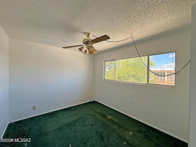 empty room with dark carpet, a textured ceiling, a ceiling fan, and baseboards