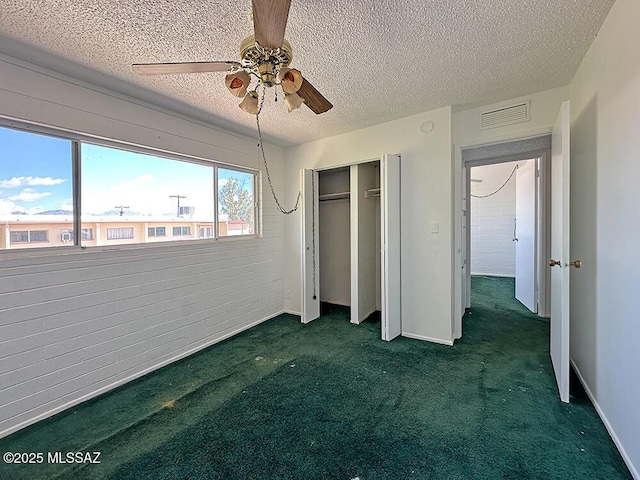 unfurnished bedroom with a textured ceiling, a closet, ceiling fan, carpet, and visible vents