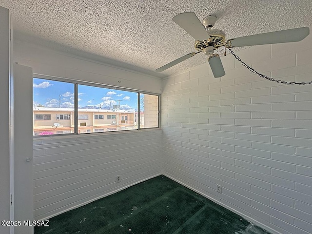 spare room with a ceiling fan and a textured ceiling