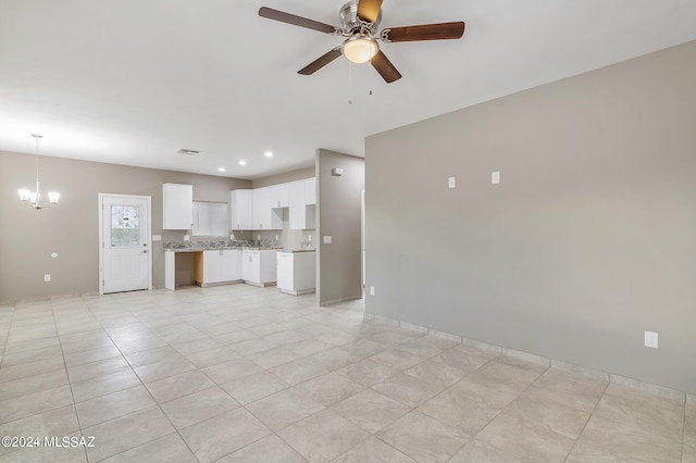 unfurnished living room featuring ceiling fan with notable chandelier and light tile patterned floors