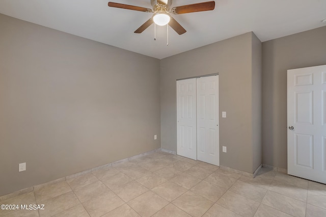 unfurnished bedroom featuring light tile patterned flooring, ceiling fan, and a closet