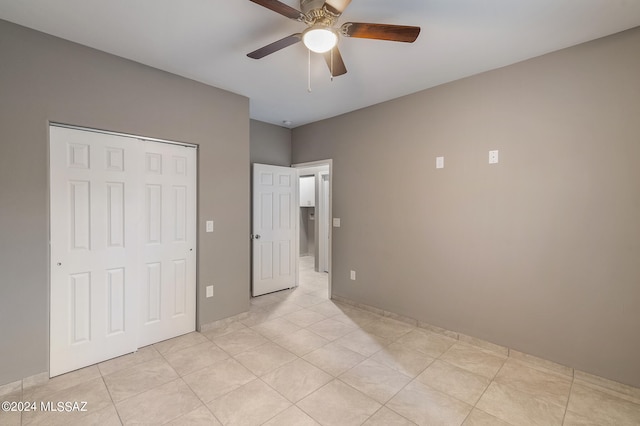 unfurnished bedroom featuring light tile patterned flooring, a closet, and ceiling fan