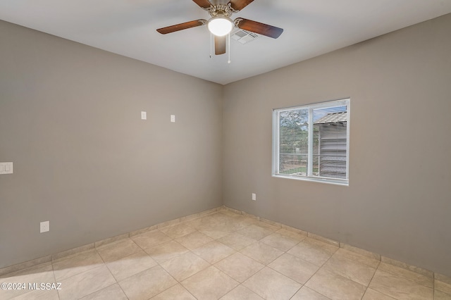 tiled spare room with ceiling fan