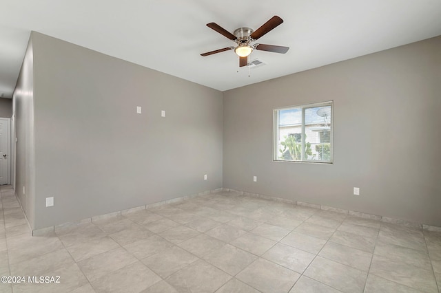 tiled spare room with ceiling fan