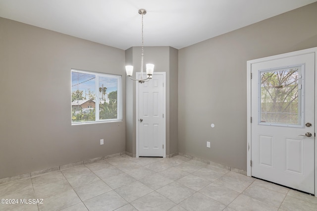 unfurnished dining area featuring an inviting chandelier and light tile patterned floors