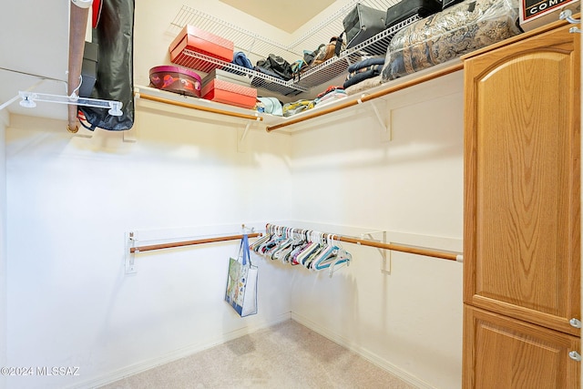 walk in closet featuring light carpet