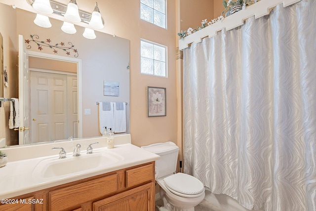 bathroom featuring a shower with curtain, vanity, and toilet