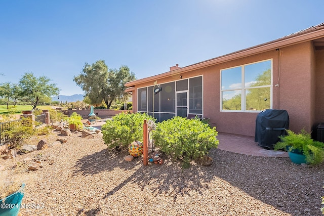 view of yard featuring a sunroom and a patio