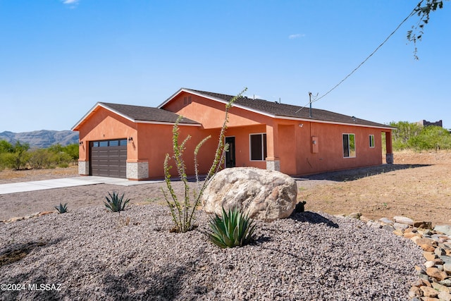 ranch-style home with a mountain view and a garage