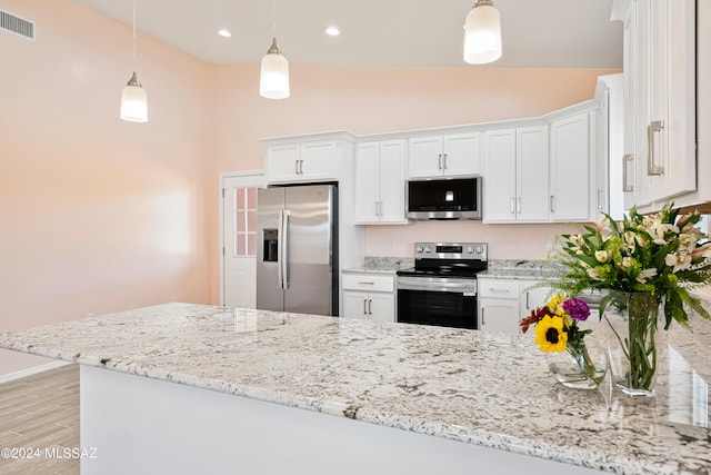 kitchen featuring lofted ceiling, white cabinets, stainless steel appliances, and pendant lighting