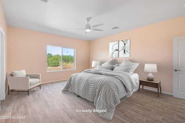 bedroom with light hardwood / wood-style floors and ceiling fan