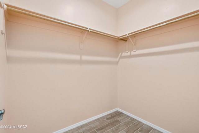 walk in closet with hardwood / wood-style flooring