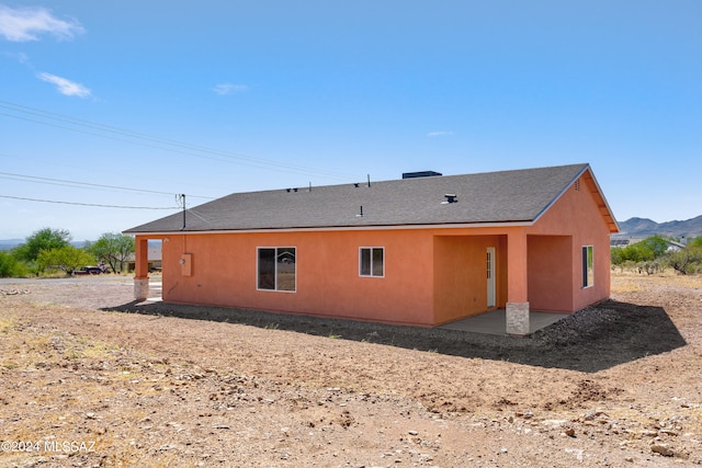 back of house featuring a mountain view and a patio area