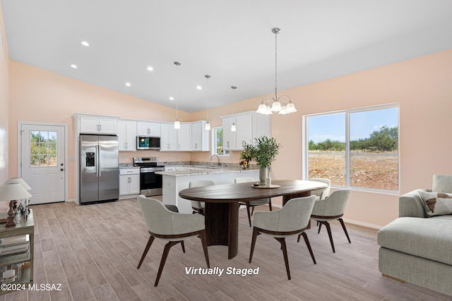 dining area with vaulted ceiling, a wealth of natural light, and light wood-type flooring