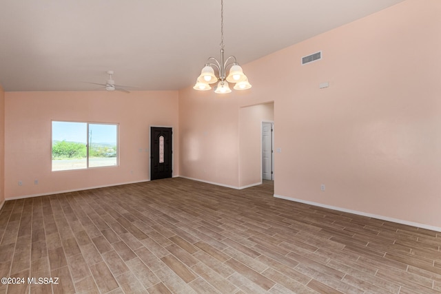 spare room with light hardwood / wood-style flooring, ceiling fan with notable chandelier, and vaulted ceiling