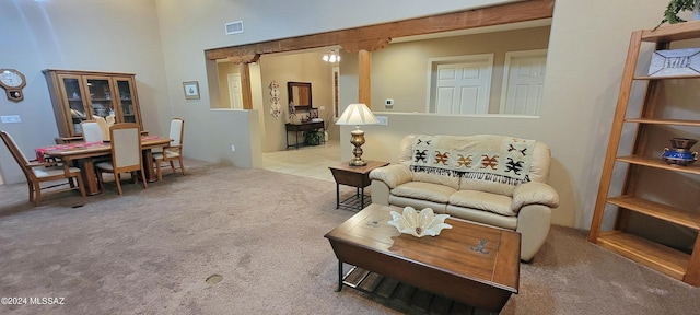 carpeted living room with a high ceiling