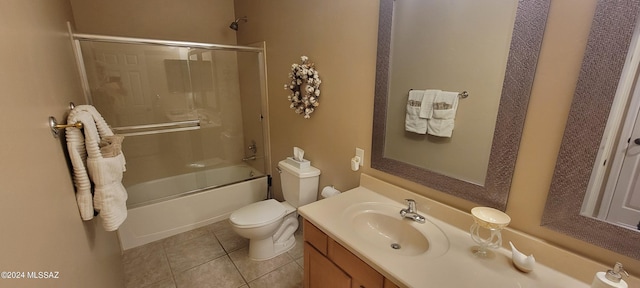 full bathroom featuring tile patterned flooring, vanity, toilet, and bath / shower combo with glass door