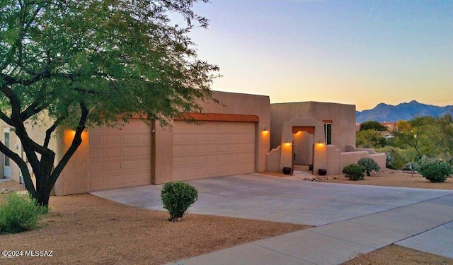 pueblo revival-style home with a mountain view and a garage