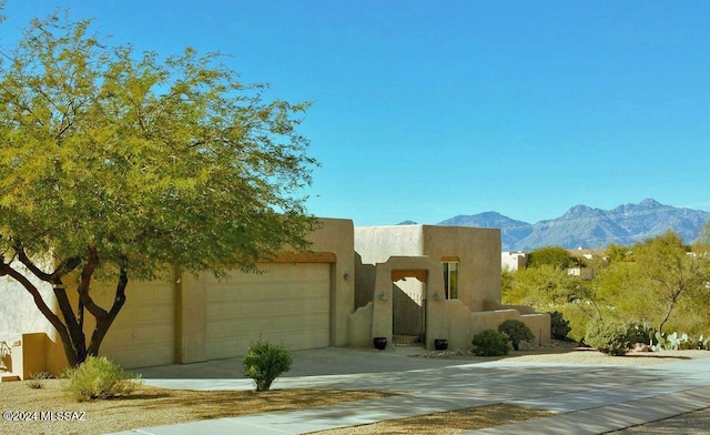 pueblo revival-style home featuring a mountain view and a garage