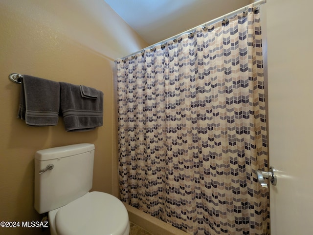 bathroom featuring walk in shower and toilet