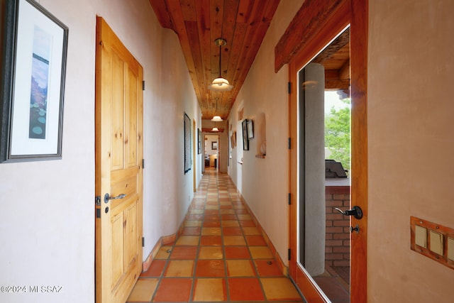 hallway featuring tile patterned floors and wooden ceiling