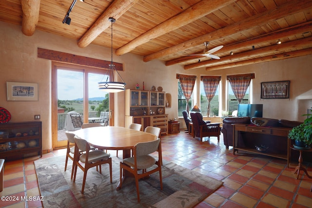 tiled dining space featuring beamed ceiling, plenty of natural light, and wood ceiling