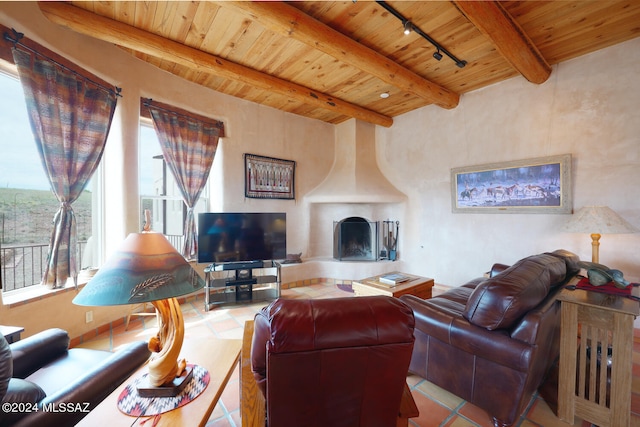 living room with tile patterned flooring, beam ceiling, a fireplace, and track lighting