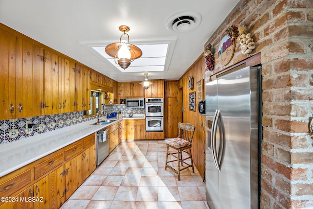 kitchen with backsplash, appliances with stainless steel finishes, and sink