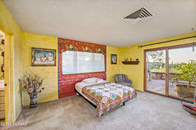 carpeted bedroom with access to outside and a textured ceiling