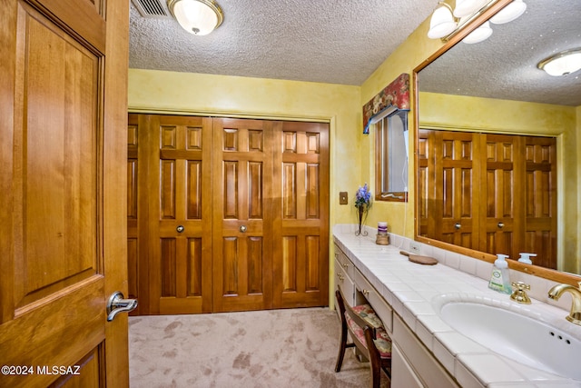 bathroom with vanity and a textured ceiling