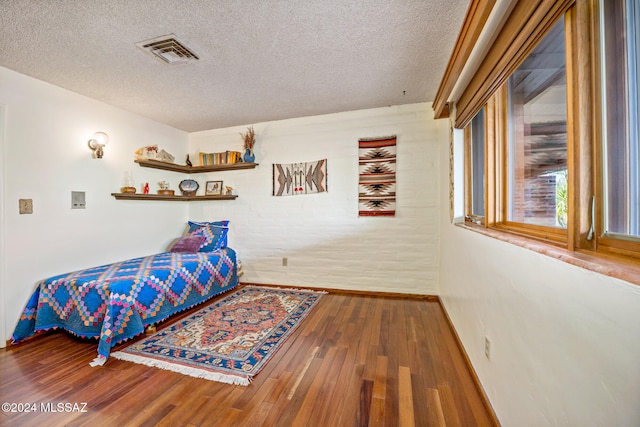 bedroom with a textured ceiling and hardwood / wood-style floors