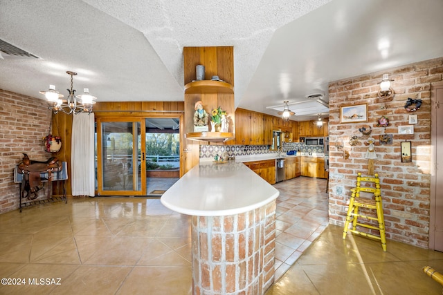 kitchen with tasteful backsplash, kitchen peninsula, stainless steel appliances, and a textured ceiling