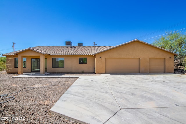 view of front of property featuring central AC and a garage