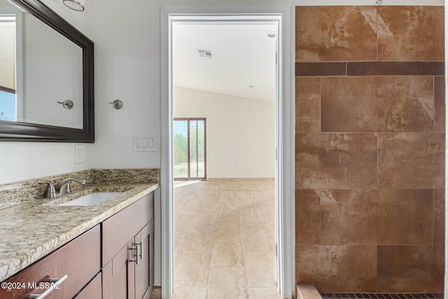 bathroom with vanity, tile patterned floors, walk in shower, and vaulted ceiling