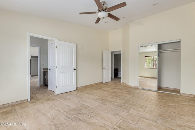 unfurnished bedroom with a closet, ceiling fan, and a towering ceiling