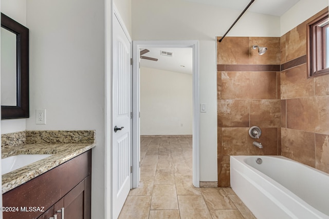 bathroom featuring tiled shower / bath, vanity, and tile patterned flooring