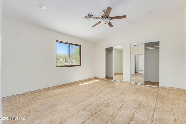 unfurnished bedroom with two closets, vaulted ceiling, and ceiling fan