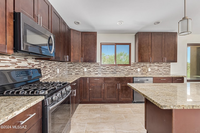 kitchen featuring pendant lighting, stainless steel appliances, tasteful backsplash, and plenty of natural light