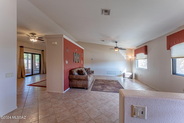 unfurnished living room with a wealth of natural light, light tile patterned floors, and ceiling fan