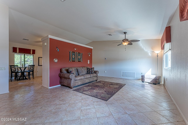 living room featuring ceiling fan, lofted ceiling, and light tile patterned flooring