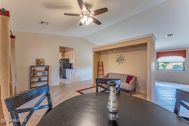 dining area with ceiling fan, light tile patterned flooring, and vaulted ceiling