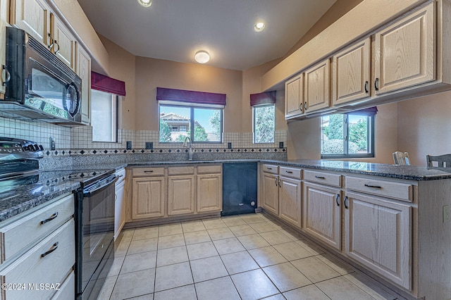 kitchen with black appliances, a healthy amount of sunlight, kitchen peninsula, and light tile patterned floors