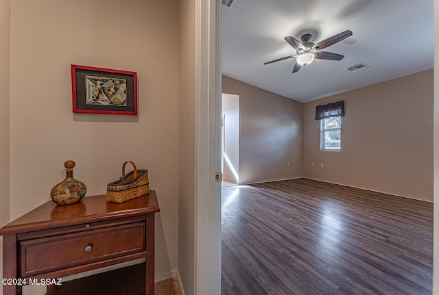 empty room with ceiling fan and dark wood-type flooring